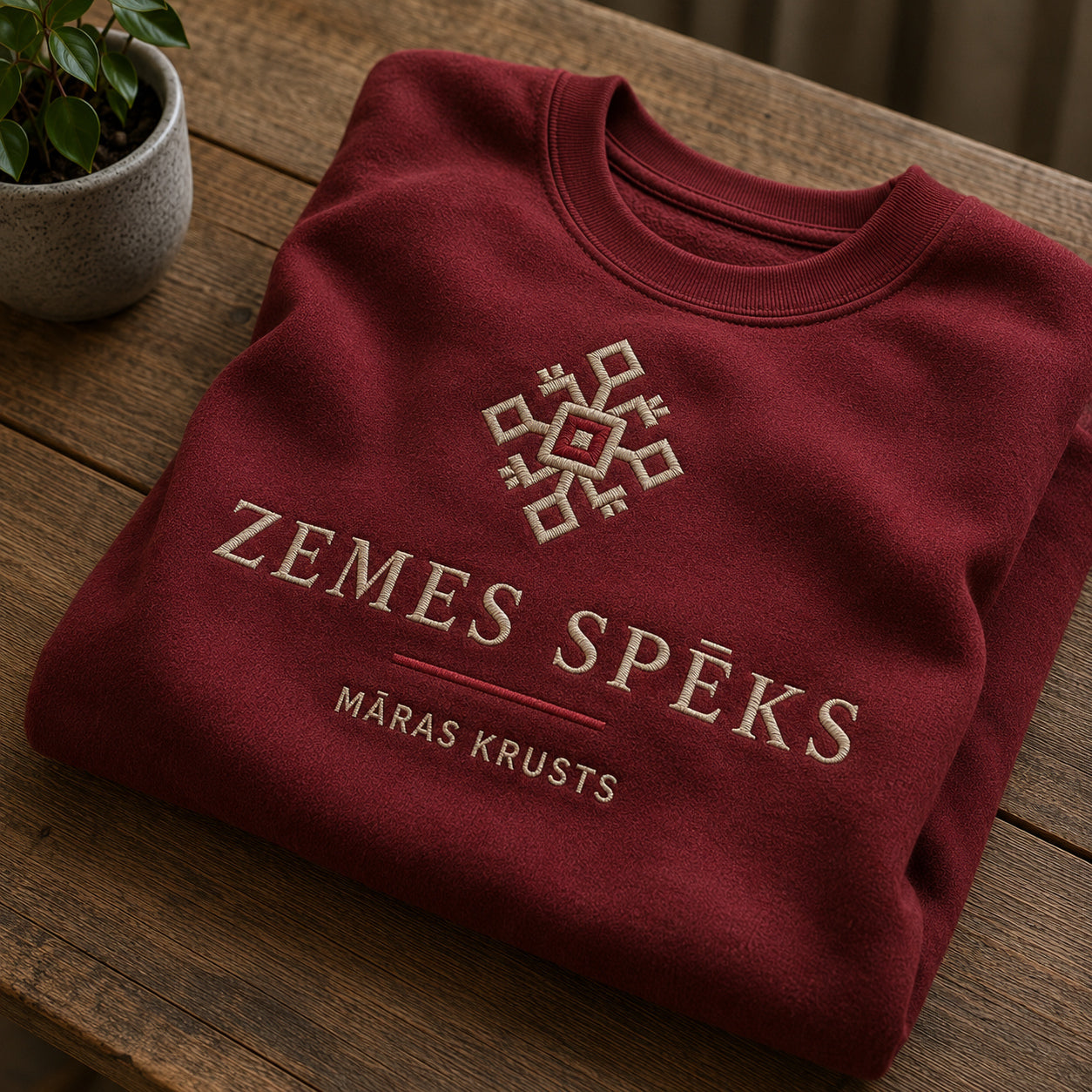 Bordo salocīts džemperis ar “Zemes spēks” izšuvumu plašākā plakanā izkārtojuma kopskatā