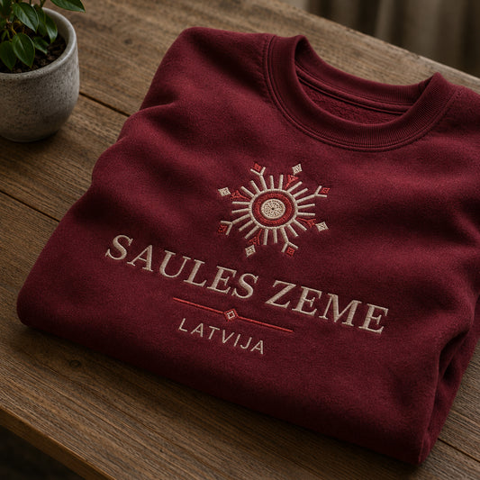 Bordo salocīts džemperis ar “Saules zeme Latvija” izšuvumu plašākā plakanā izkārtojuma kopskatā
