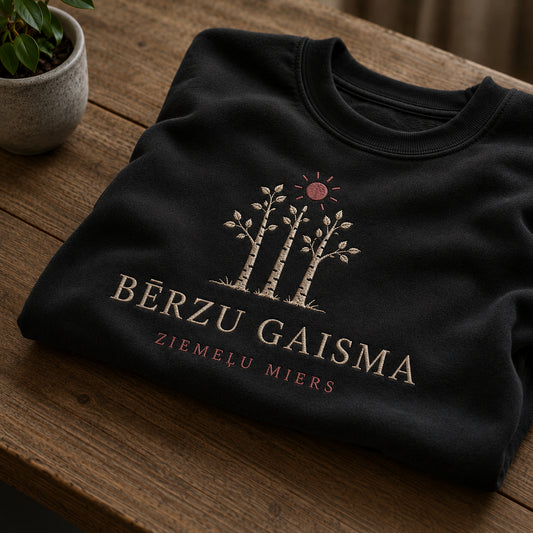 Melns salocīts džemperis ar “Bērzu gaisma” izšuvumu plašākā plakanā izkārtojuma kopskatā