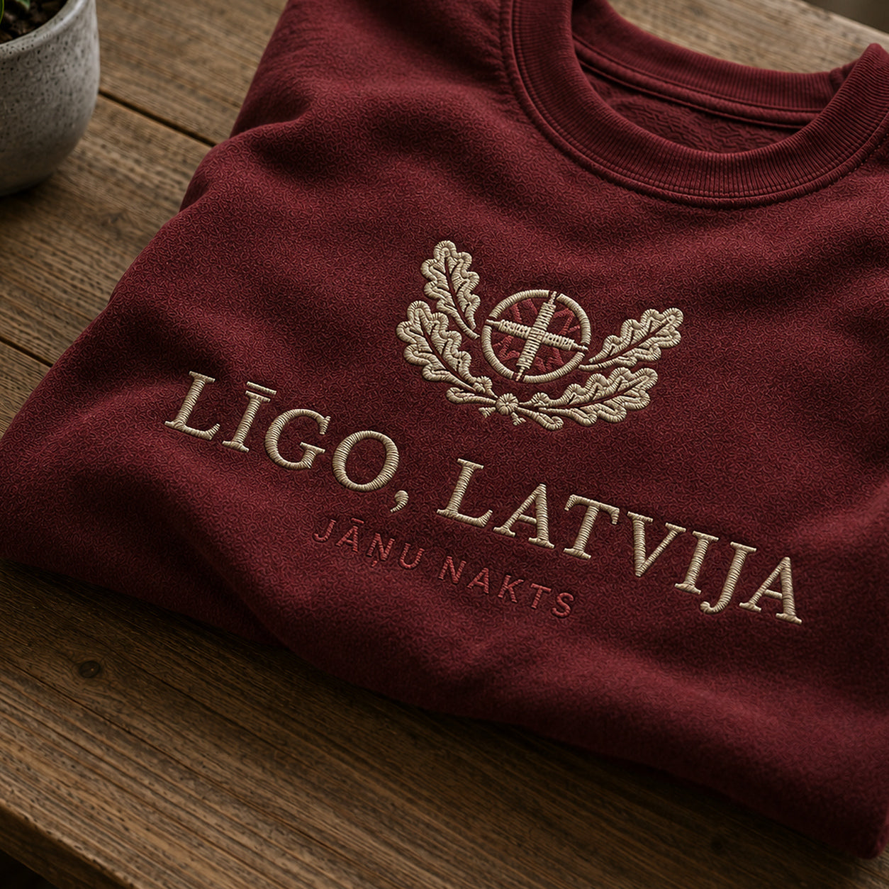 Tuvāks “Līgo, Latvija” kompozīcijas skats uz bordo salocītu džemperi ar tekstu “Līgo, Latvija” un apakštekstu “Jāņu nakts”
