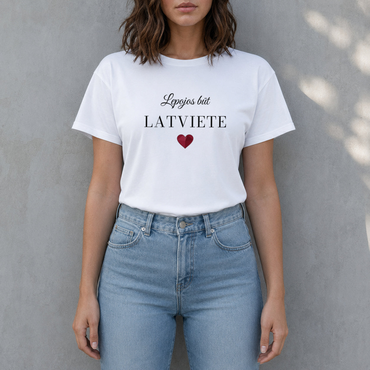 Sieviete baltā T kreklā ar Lepojos būt LATVIETE apdruku