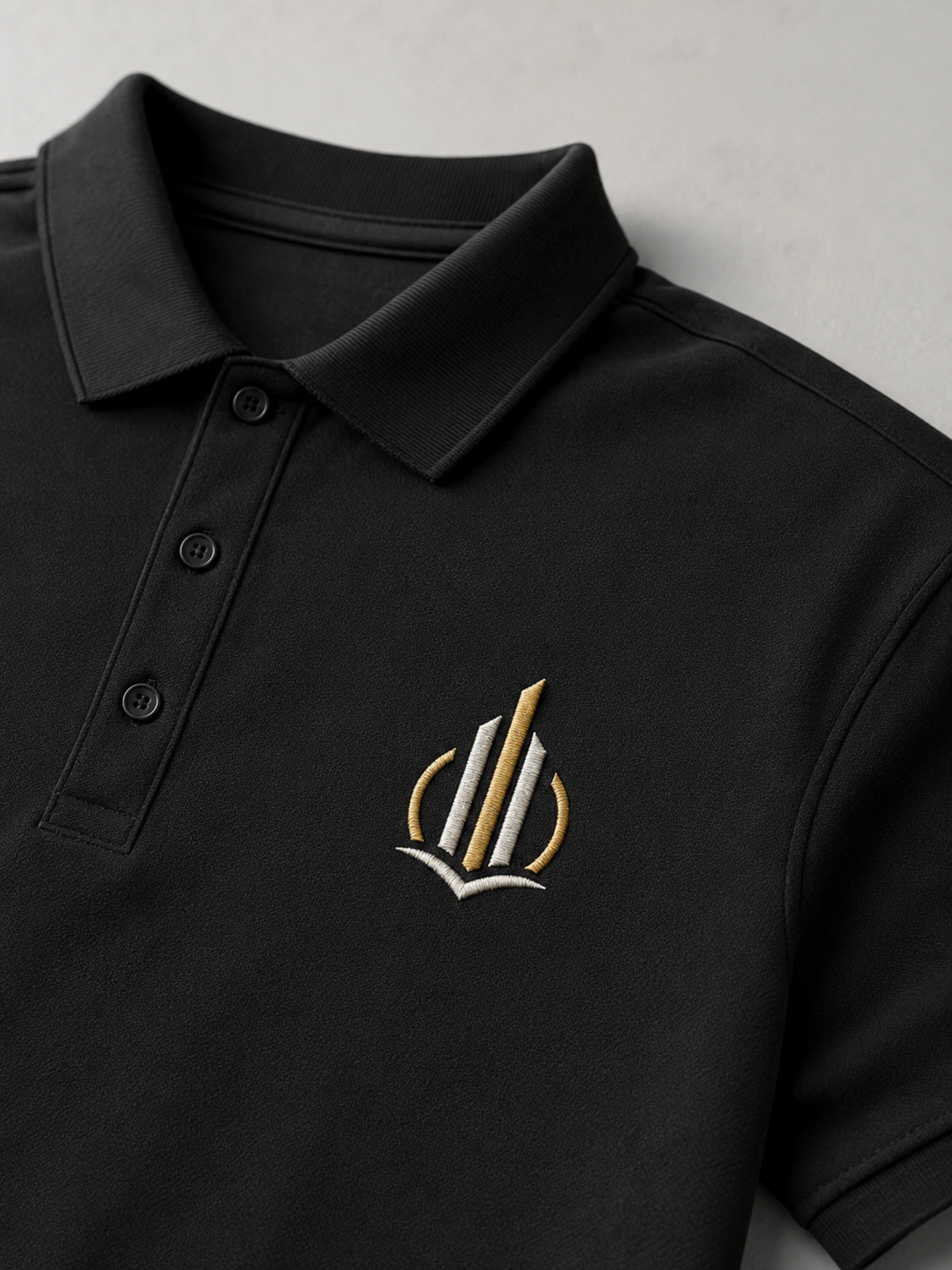 Neliela logo izšūšana uz melna polo krekla, uzņēmuma apģērba personalizācija